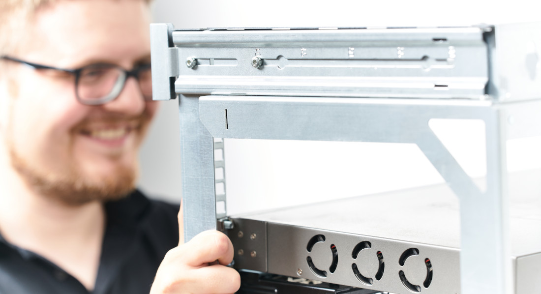 Mann verstellt die Tiefe am X-Rack Mann verstellt die Tiefe am X-Rack