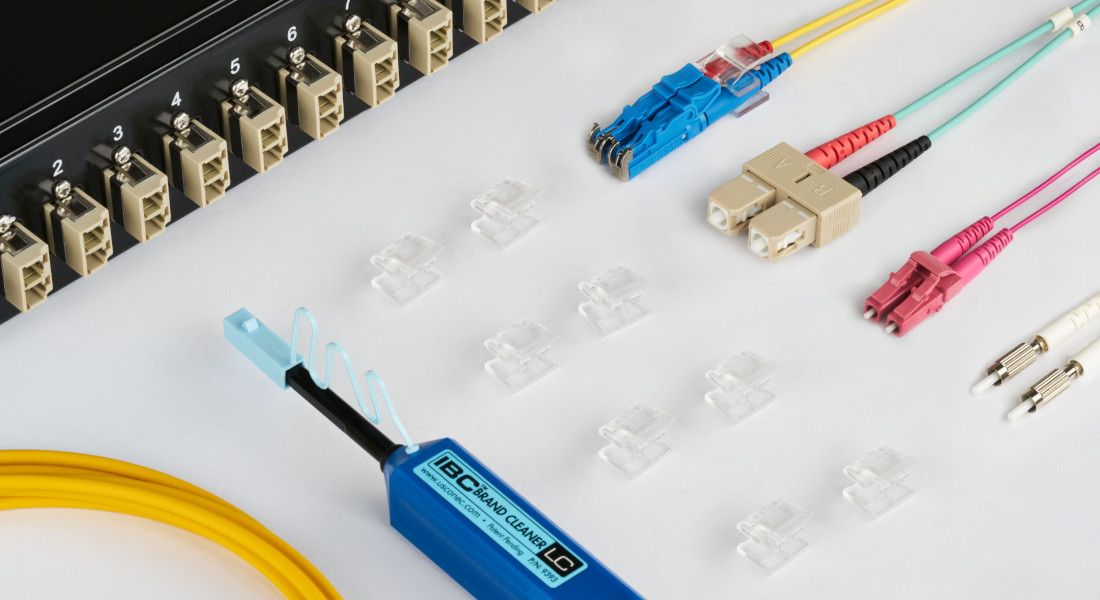 Netzwerkkomponenten und Werkzeuge, darunter LWL-Patchkabel Netzwerkkomponenten und Werkzeuge, darunter LWL-Patchkabel und Werkzeuge, darunter ein Patchpanel, LWL-Patchkabel, farbige Kabel und ein Abisolierwerkzeug.