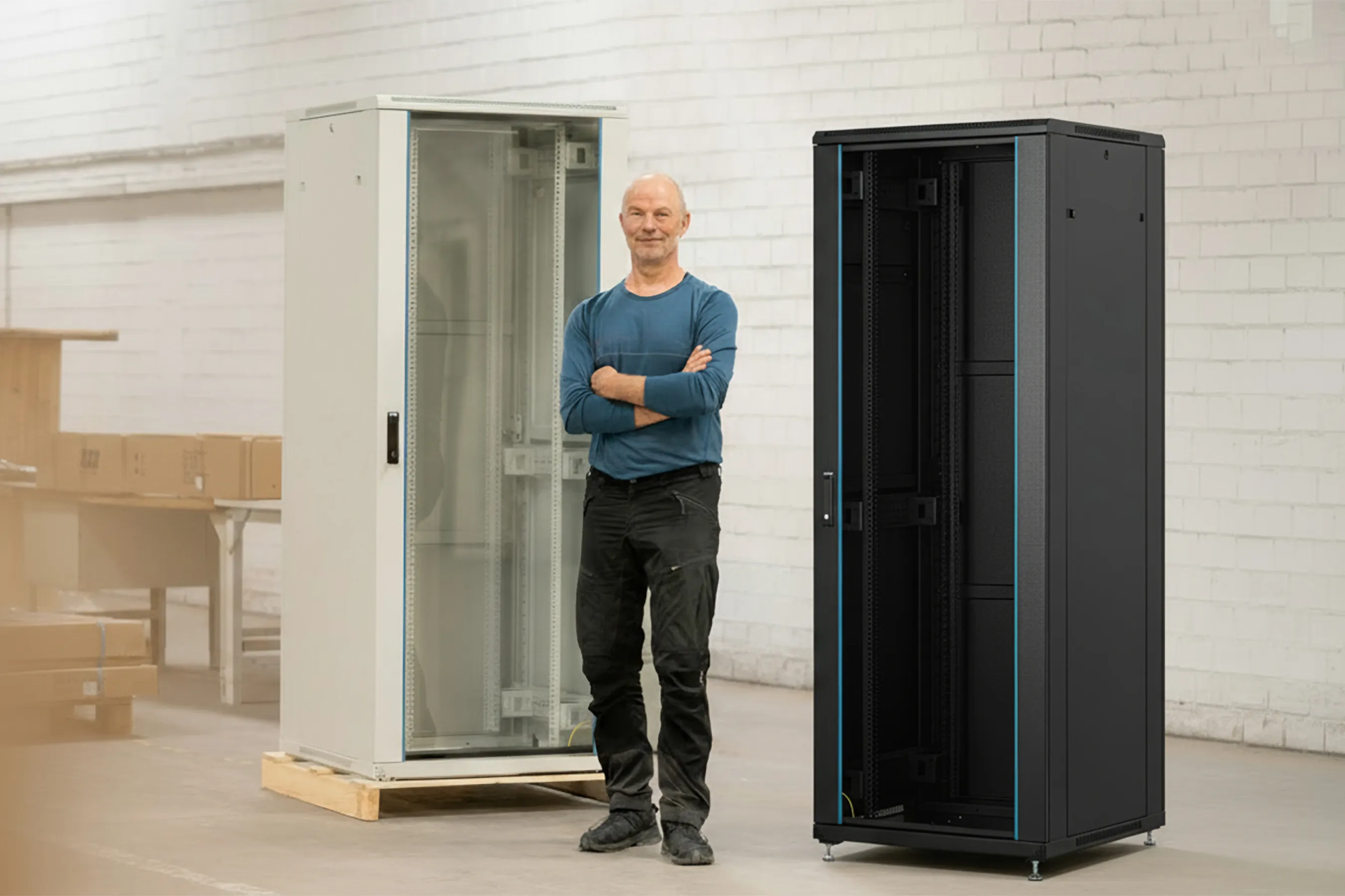 Ein Mann steht in einer Halle vor einem 19" Netzwerkschrank