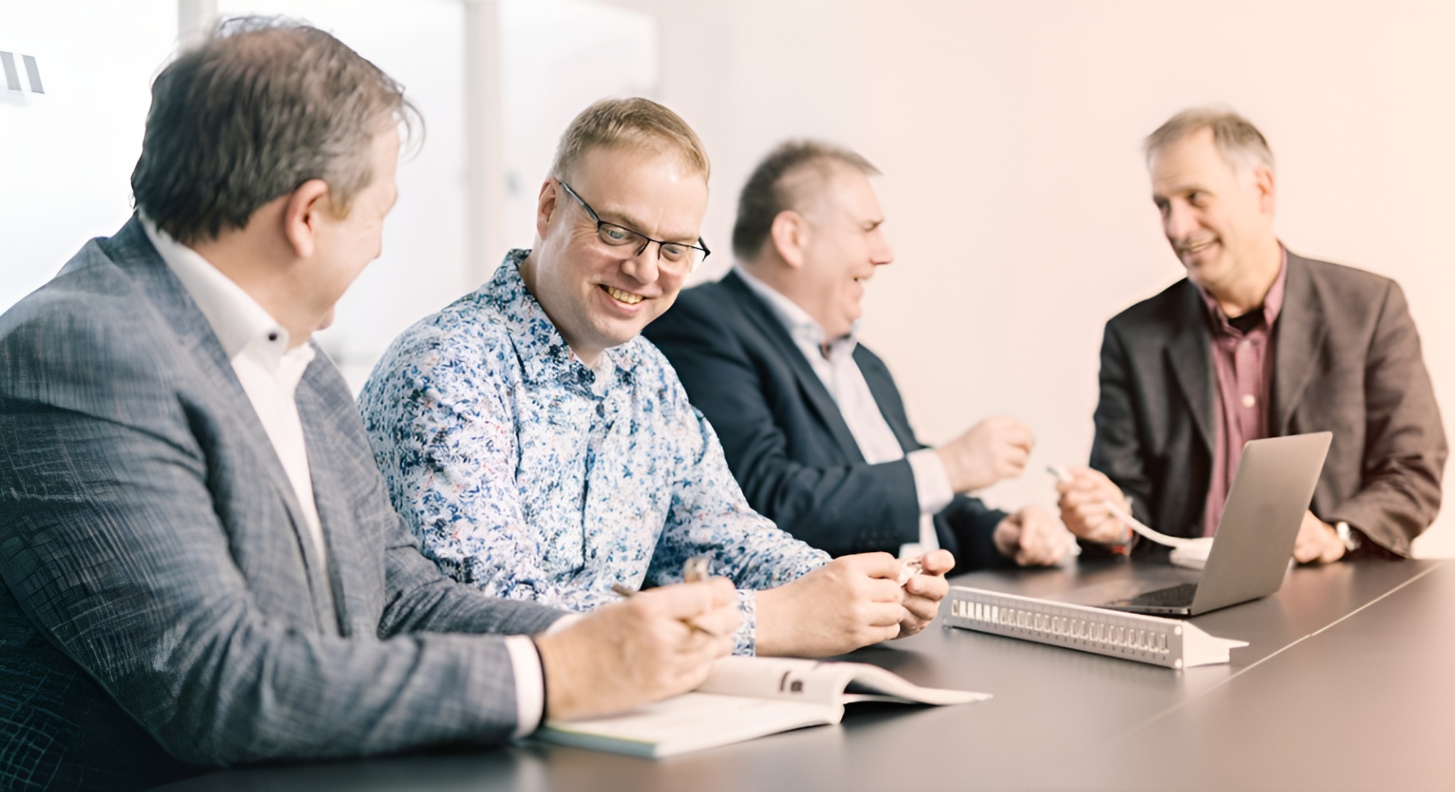 Geschäftsmänner im Meeting mit Laptop und Technikkomponenten – erfolgreiche Teamarbeit und Beratung im Business-Umfeld
