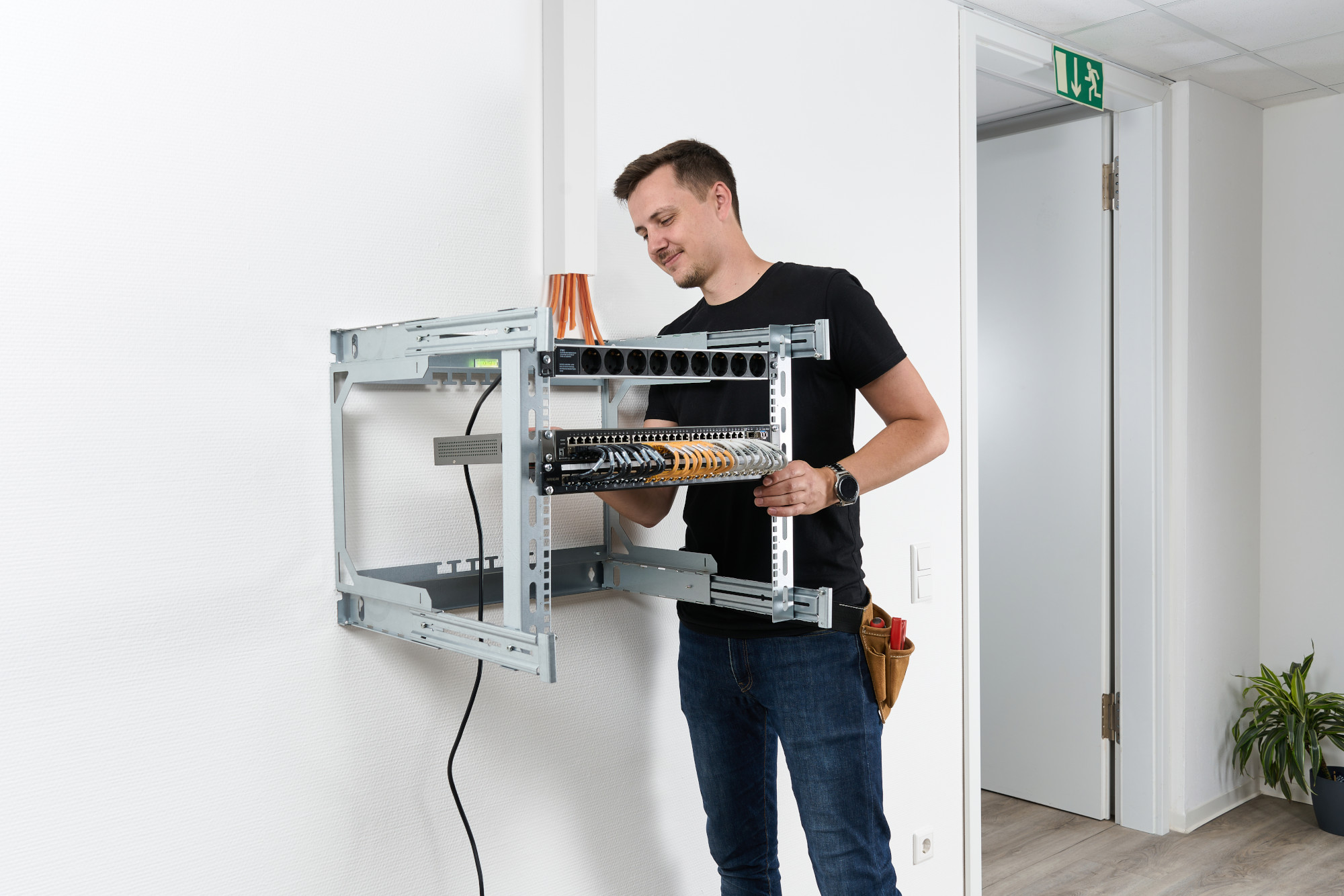 Mann befestigt Komponenten am X-Rack Mann befestigt Komponenten am X-Rack
