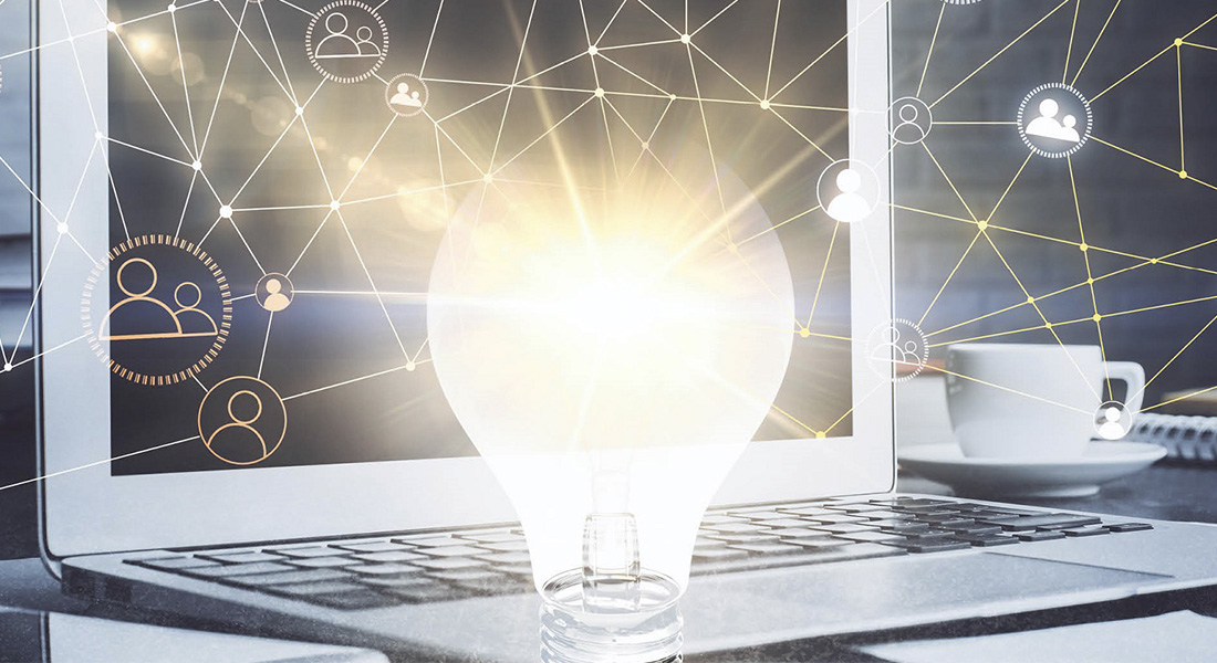 Glowing lightbulb in front of laptop Glowing lightbulb in front of laptop