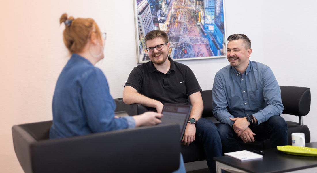 EFB-Elektronik employees sitting on a sofa and talking | EFB-Elektronik