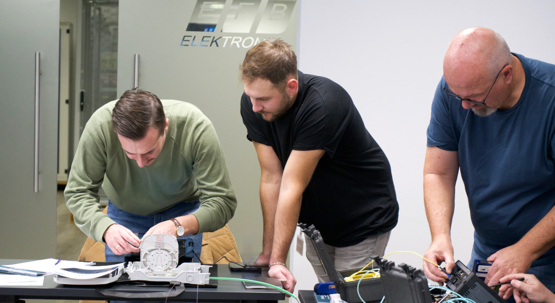 Impressionen eines EFB-Elektronik Workshops - Teilnehmer guckt einem anderen Teilnehmer bei der Anwendung eines Messgeräts über die Schulter