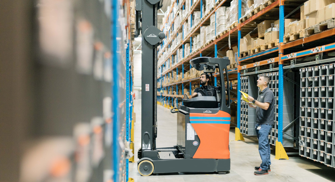 Mitarbeiter im Lager von EFB-Elektronik bei der Kommissionierung mit Schubmaststapler im Hochregallager