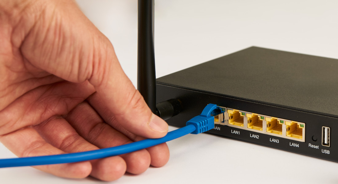 Netzwerkkabel wird in WLAN-Router eingesteckt – Einrichtung von Heimnetzwerk mit RJ45-Verbindung Netzwerkkabel wird in WLAN-Router eingesteckt – Einrichtung von Heimnetzwerk mit RJ45-Verbindung