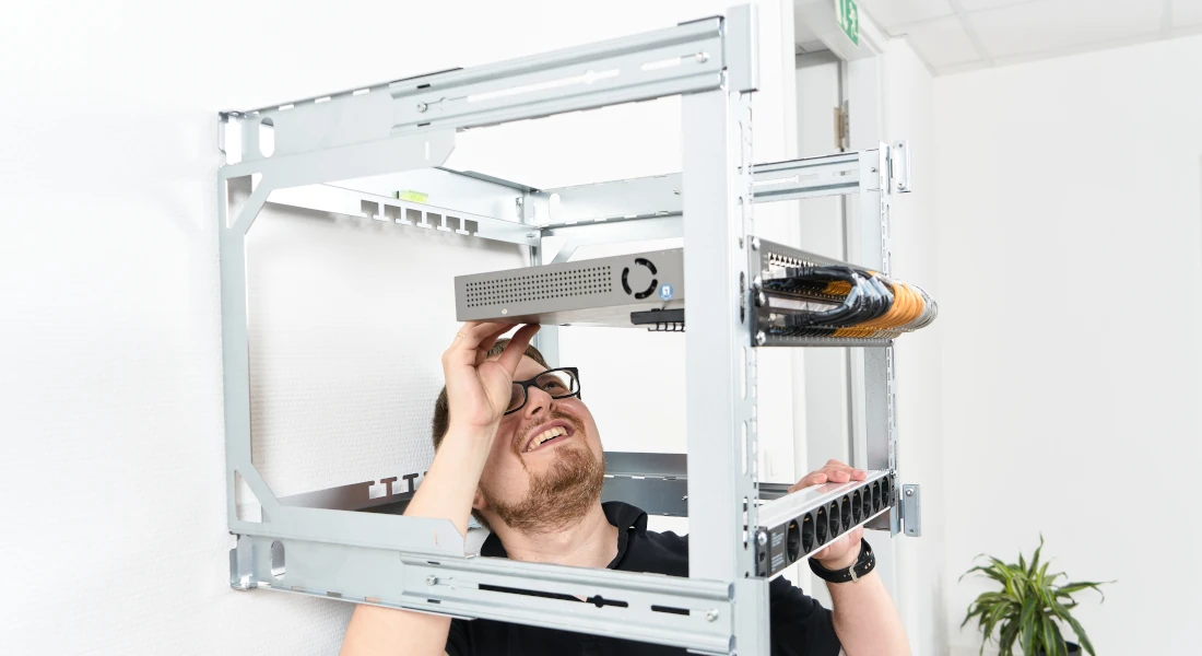 An installer is working on the X-Rack from below