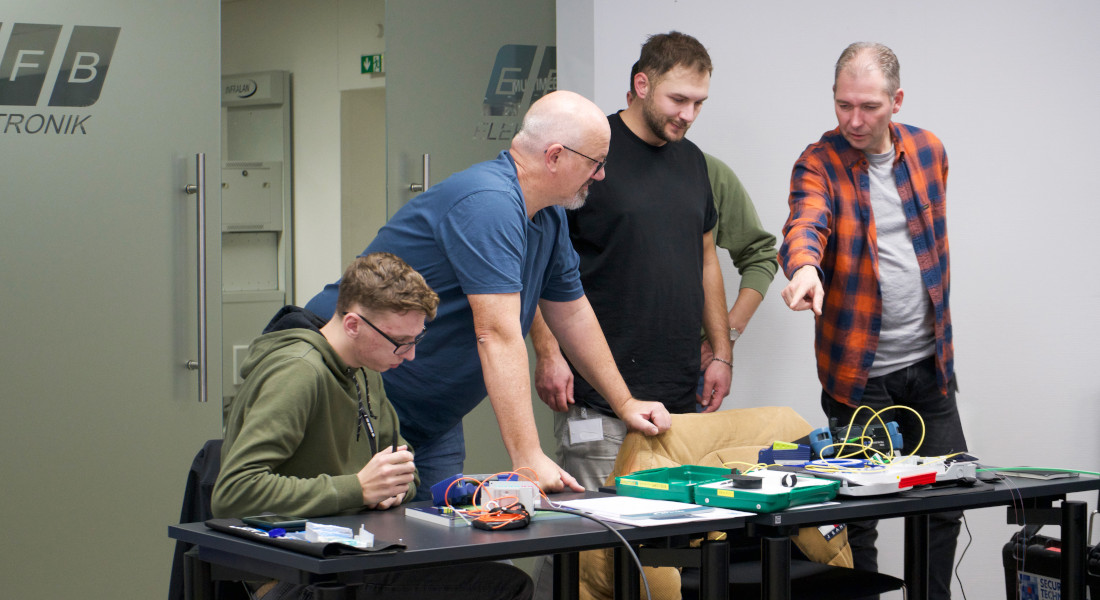 Impressionen eines EFB-Elektronik Workshops - Dozent erklärt Teilnehmern die praktische Anwendung von Messgeräten