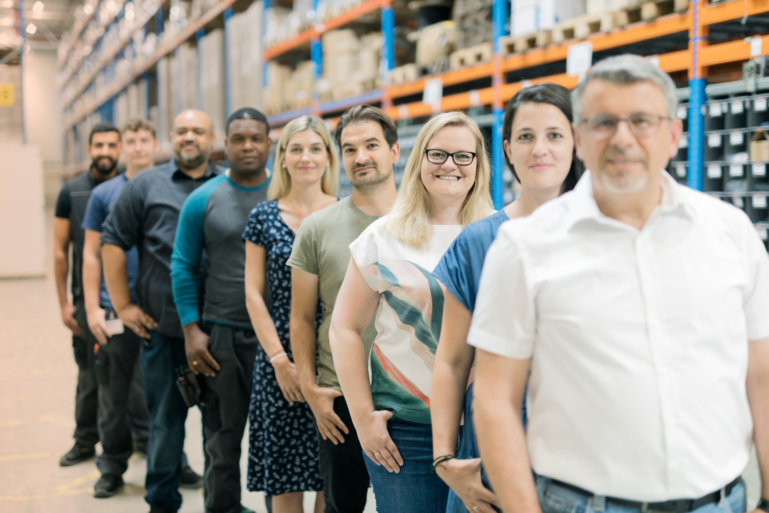 Employees of EFB-Elektronik stand in a row in the warehouse
