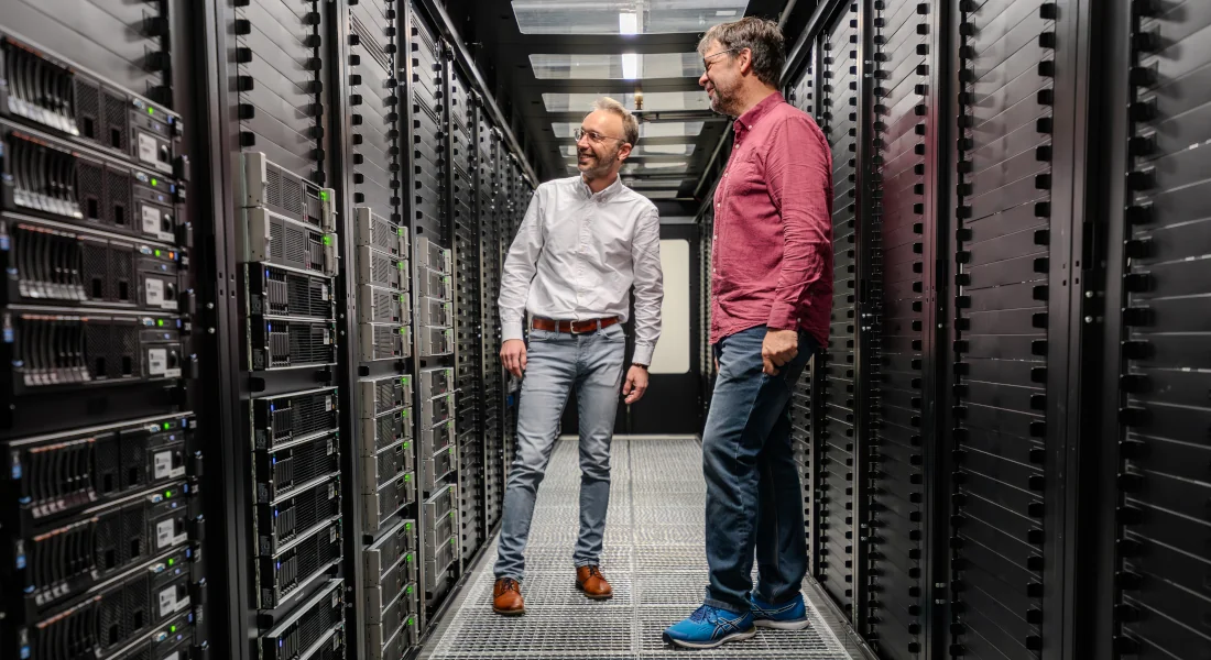 Rechenzentrum mit Netzwerkschränken und Experten im Austausch – EFB-Elektronik