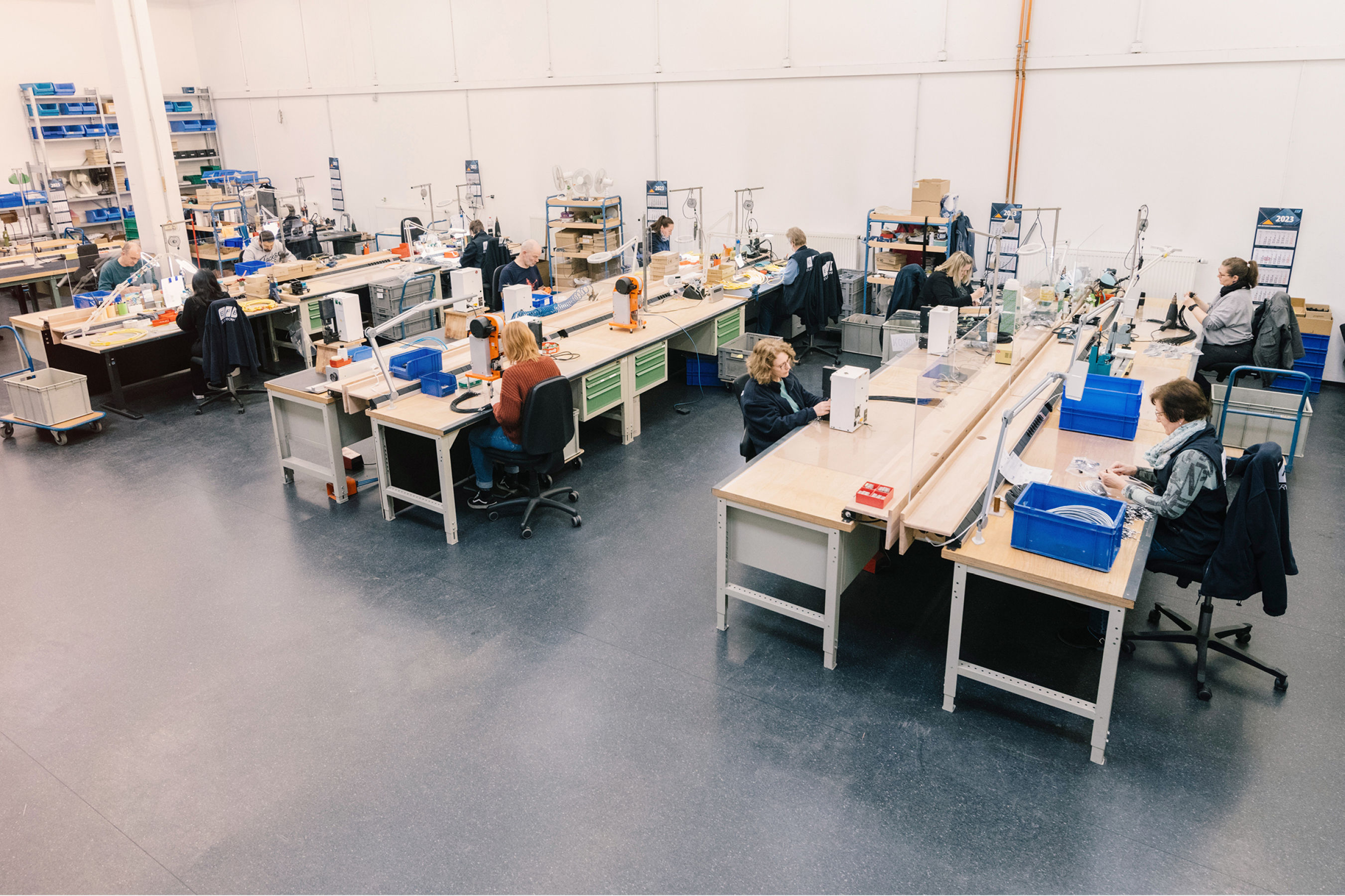 An overall view shows the production of EFB-Elektronik in Bielefeld. Various cheerful employees can be seen in the picture - they are busy with assembly.