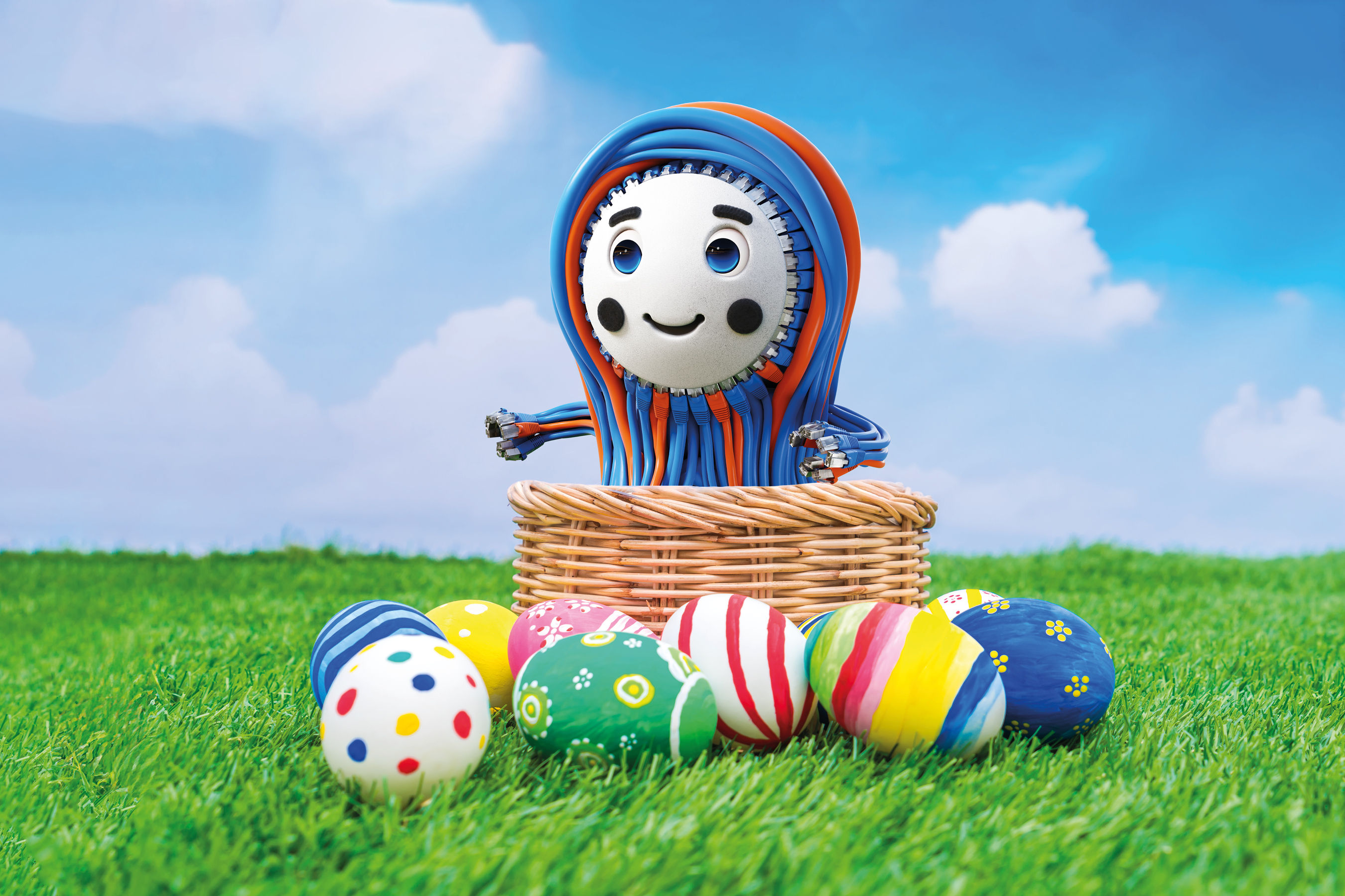 Bunte Ostereier und Patchy, das fröhliche, Maskottchen von EFB-Elektronik, in einem Korb auf grünem Gras vor einem blauen Himmel.